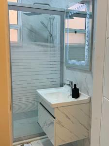 アンマンにあるBeit Ahlan Suites 7の洗面台とシャワー付きの白いバスルーム