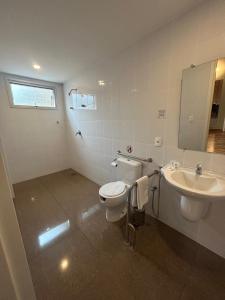 a bathroom with a toilet and a sink at Impar Suites Barao de Cocais in Barão de Cocais +48 photos
