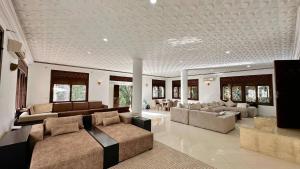 Una gran sala de estar con sofás y un televisor. en Malabata Seaview Villa, en Tánger