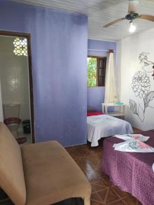 a bedroom with two beds and a blue wall at Pousada Villa da Música Beira Mar Dàlia Pontal Centro in Paraty +10 photos