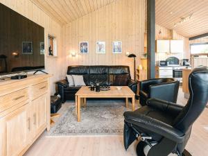 a living room with a leather couch and a table at 4 star holiday home in Øster Assels-By Traum in Øster Assels