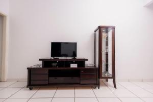 une commode avec une télévision et un miroir dans l'établissement Apto Comfort Central (Perto de tudo), à São Lourenço
