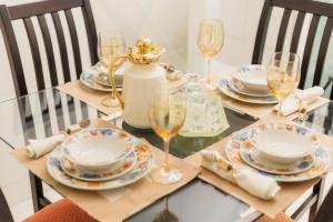 une table avec des assiettes et des verres à vin dessus dans l'établissement Apto Comfort Central (Perto de tudo), à São Lourenço
