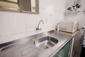 - un évier en acier inoxydable dans la cuisine équipée d'un four micro-ondes dans l'établissement Apto Comfort Central (Perto de tudo), à São Lourenço 47 autres photos