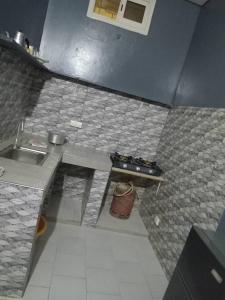 a kitchen with a stove and a sink in it at CHEZ Mamadou et Binetou in Mbour