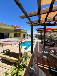 a patio with a pool and a table and chairs at شاليه بانا جرش jerash in Khirbat ‘Uşfūr