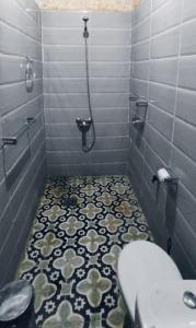 Łazienka z prysznicem, toaletą i podłogą wyłożoną kafelkami w obiekcie bain de sabl merzouga bin de sablle w mieście Merzouga