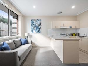 a living room with a couch and a kitchen at Prickly Pear Stays in Mayfield in Mayfield