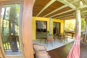 a patio with a table and chairs on a deck at Casa Janaina Ilhabela in Ilhabela