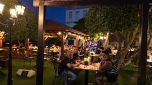 a group of people sitting at tables on a patio at night at Casa Blanca in Pag