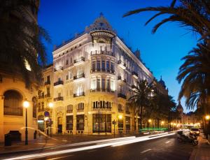 um grande edifício branco numa rua à noite em One Shot Palacio Reina Victoria 04 em Valência