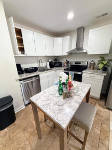 a kitchen with a marble table and white cabinets at Renovated 2 Bedroom In Durham! Superhost! in Durham +3 photos