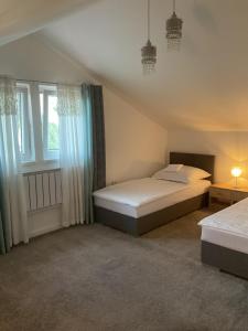 a bedroom with two beds and two windows at Charming home near old town in Košice