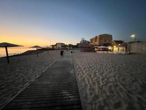 a pathway on a beach with umbrellas on it at Cortecasa, between the sea and nature in Cortegaça