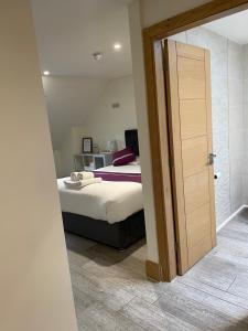 a bedroom with a bed and a door to a bathroom at Oakham Hotel in Oakham