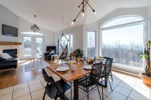 a dining room and living room with a table and chairs at Bleuzen chalet entier in Petite-Rivière-Saint-François