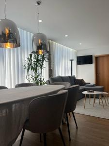 ein Wohnzimmer mit einer Couch und einem Tisch und Stühlen in der Unterkunft Sequeira Arantes Casa 1 in Terras de Bouro