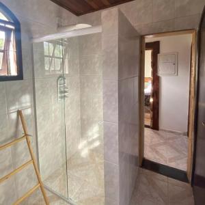 a shower with a glass door in a bathroom at Pousada Valle do Sol in Campos do Jordão
