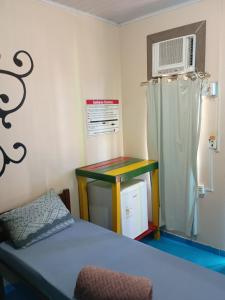 a room with a bed and a table and a microwave at Pousada Primavera in Bonito +55 photos