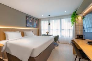 a hotel room with a large bed and a desk at Cozzy Premium Paulista Hotel in Sao Paulo +96 photos