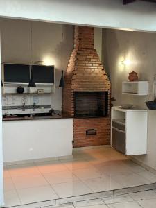 a kitchen with a brick fireplace in a room at Linda casa confortável em Manaus in Manaus