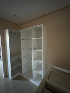 a white closet with white shelves in a room at Linda casa confortável em Manaus in Manaus