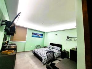 a bedroom with a bed and a tv in it at ACEQUIA Master Suites BLACK & WHITE in Cuautitlán Izcalli