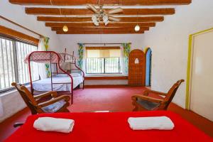 1 dormitorio con 1 cama, mesa roja y sillas en New Bamboo La Campiña Pool & Countryside, en Chiconcuac