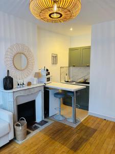 a kitchen with a table and a fireplace with a mirror at Cozy studio en centre ville in Beauvais