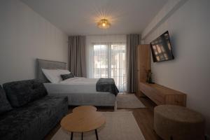a hotel room with a bed and a couch at SARAJEVO SUITES No 23 Free parking in Sarajevo