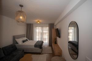 a bedroom with a bed and a mirror and a couch at SARAJEVO SUITES No 23 Free parking in Sarajevo +34 photos