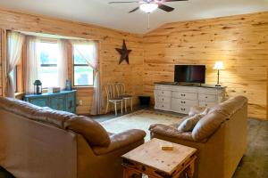 uma sala de estar com sofás de couro e uma televisão em Emory Escape with Pond Access Less Than 13 Mi to Lake! em Emory