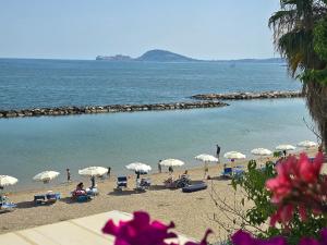 a beach with white umbrellas and people on the beach at Filoverde vicino il CONI e il mare in Formia