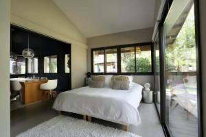 ein Schlafzimmer mit einem Bett, einem Schreibtisch und Fenstern in der Unterkunft Superb Contemporary Villa Near Montpellier in Castelnau-le-Lez + 32 Fotos