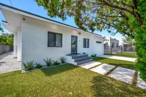 une maison blanche avec une cour dans l'établissement Lux Modern 4BR Villa with Pool in Miami, à Miami