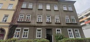 a large brick building with white windows on a city street at Bright & Spacious Stay in Graz in Graz
