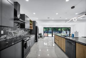 - une cuisine avec des comptoirs en noir et blanc dans l'établissement Lux Modern 4BR Villa with Pool in Miami, à Miami