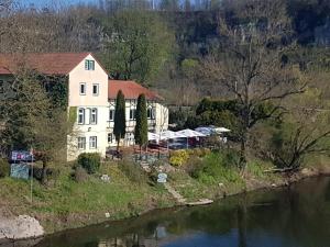 a house on a hill next to a river at Altes Saale Fährhaus in Naumburg