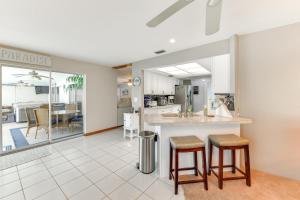 a kitchen and living room with a counter and stools at Fish, Swim and Relax Canal-Front Port Charlotte Gem in Port Charlotte
