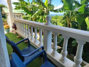 普罗维登西亚EcoApartamentos Sunset Life的一个带两把椅子的门廊,享有海景