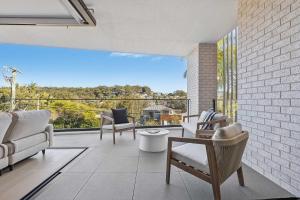 een woonkamer met stoelen en een groot raam bij Solea in Avoca Beach
