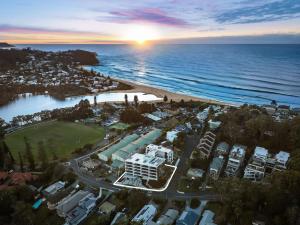 une vue aérienne d'un complexe hôtelier au bord de l'océan dans l'établissement The Gallery by Coast Hosting, à Avoca Beach