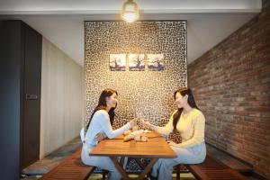 dos mujeres sentadas en una mesa con copas de vino en K Boutique Hotel, en Yeosu