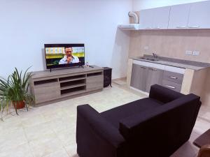a living room with a couch and a flat screen tv at Casa Azul in La Quiaca +2 photos