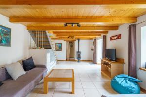 Una sala de estar con un sofá y un televisor. en Avel Mor - Proche de Quimper, en Pluguffan
