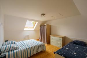 Un dormitorio con una cama y una cómoda y una ventana. en Avel Mor - Proche de Quimper, en Pluguffan