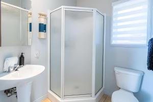 プティット・リヴィエール・サン・フランソワにあるBleuzen appartement du bas vue sur fleuve , Spa, WOWのトイレと洗面台を備えた白いバスルーム +25枚の写真