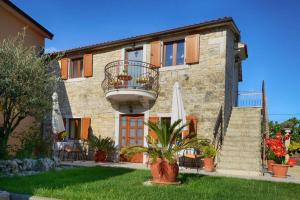a house with a balcony and an umbrella at Apartment in Baderna - Istrien 44223 in Baderna