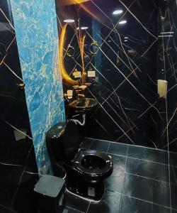 a bathroom with a black toilet and a mirror at Herencia Hotel by Dream Vacation in Pasto