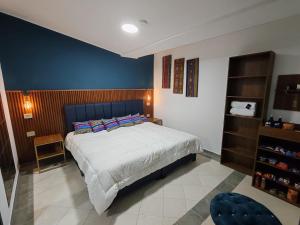 a bedroom with a large bed and a blue wall at Herencia Hotel by Dream Vacation in Pasto